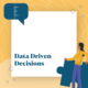 white square with a yellow border person with dark hair wearing a yellow top and blue trousers holding a blue jigsaw puzzle piece looking at the text saying data driven decisions in blue
