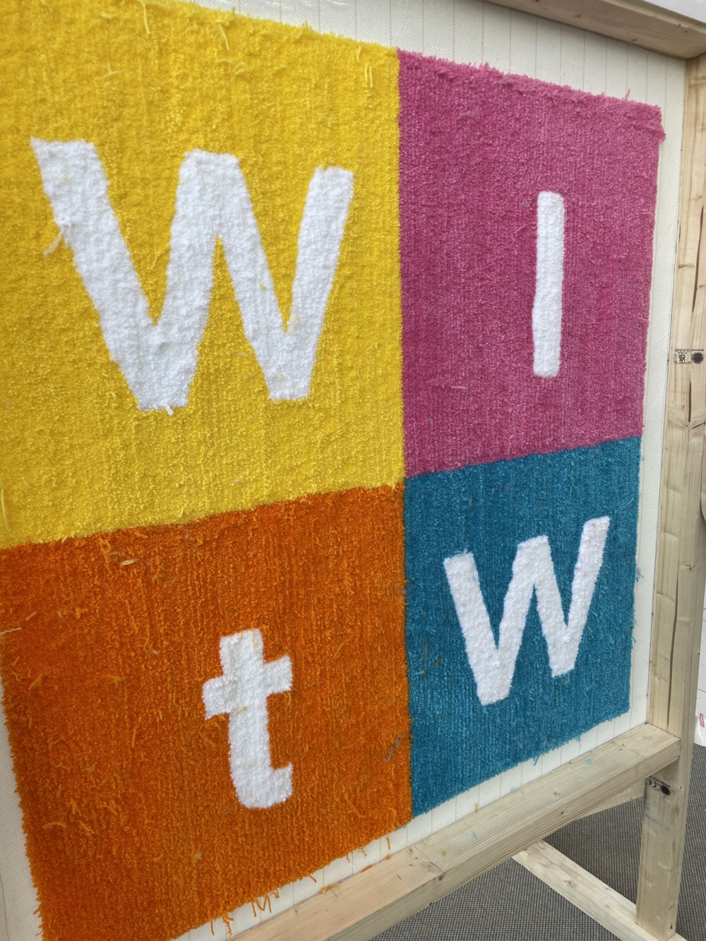 four colourful textiles with the letters W I T W in a grid